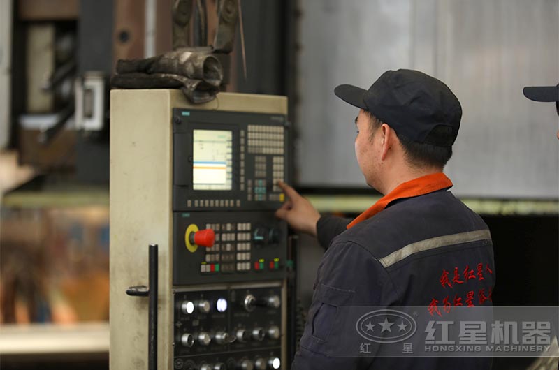 紅星廠家員工正在為移動破碎機零部件生產(chǎn)編程